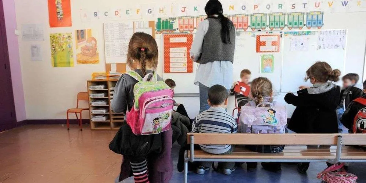 Classe d’école avec une maîtresse et des enfants